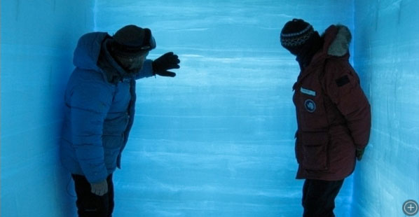 Chief Scientist Ken Taylor and science tech Anais Orsi looking at layers in backlit snowpit.
